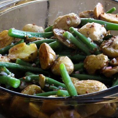 A warm roasted baby potato salad with juicy green beans, tossed in a simple mustard vinaigrette. It's mayo-free and perfect for summertime parties!