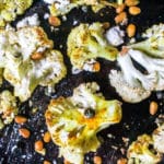 Sheet pan cauliflower tossed in a sweet curry seasoning, roasted with pine nuts and capers, and finished with feta cheese.