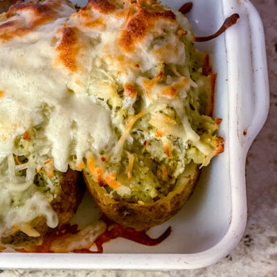 Twice baked potatoes mashed with pesto and then topped with melty swiss cheese! Freezes and reheats great, for a delish home lunch.