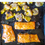 Orange marmalade and maple syrup "candy" salmon filets, served alongside creamy smashed potatoes. A great sheet pan meal!