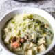 Creamy slow cooker chowder with chicken, salty ham, chopped spinach, and topped with croutons and grated swiss.