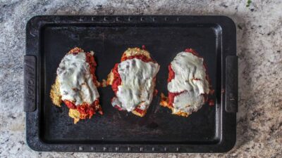 Chicken parm made on a sheet pan, prepped ahead of time, too! Crispy chicken smothered in zesty quick-made marinara and melty mozzarella.